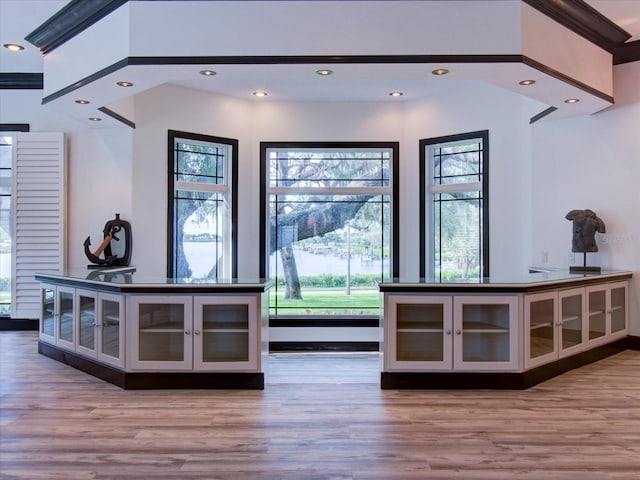 bar featuring crown molding and light hardwood / wood-style flooring