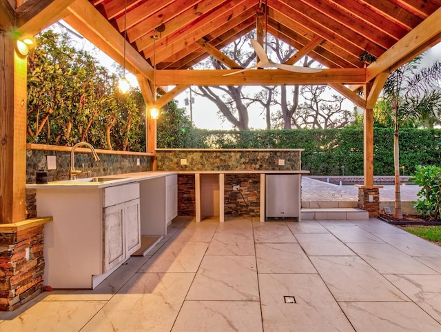 view of patio / terrace featuring a gazebo, sink, and an outdoor kitchen