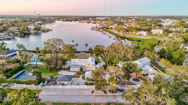 aerial view at dusk featuring a water view