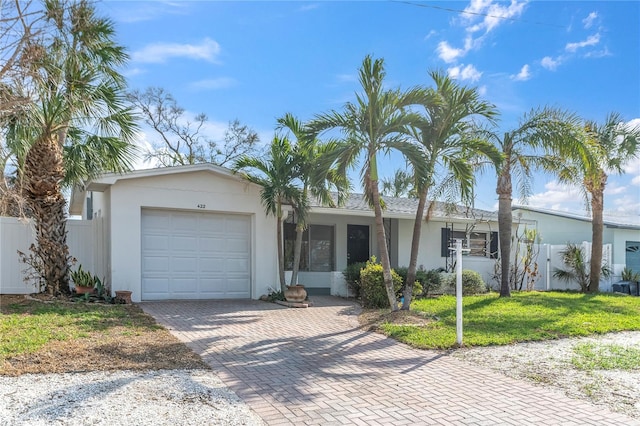 ranch-style home with a garage and a front lawn