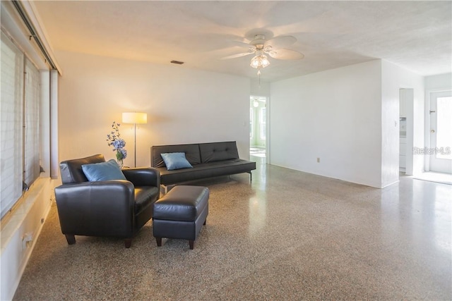 living room with ceiling fan and a wealth of natural light