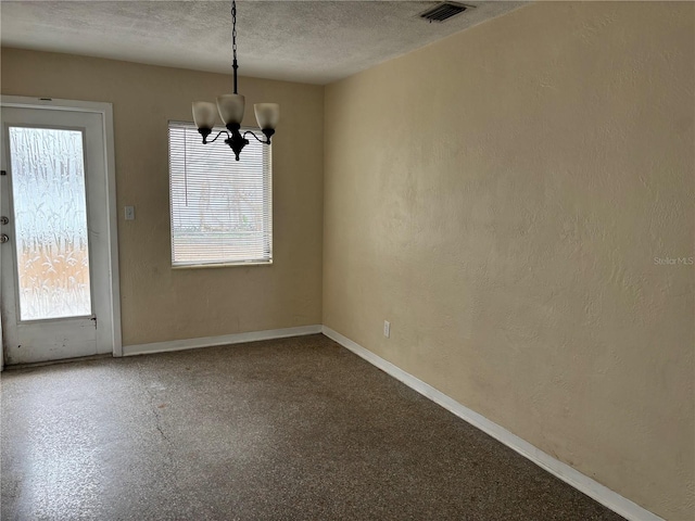 unfurnished dining area with a chandelier and a textured ceiling