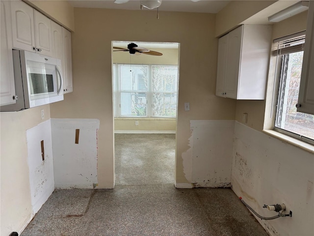 kitchen featuring ceiling fan, plenty of natural light, and white cabinets