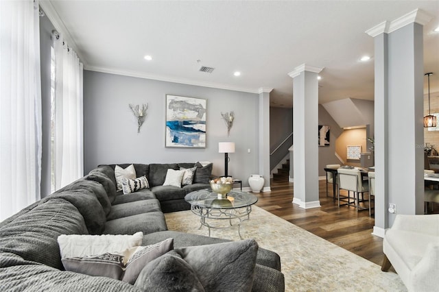 living room featuring ornate columns, dark hardwood / wood-style floors, and ornamental molding