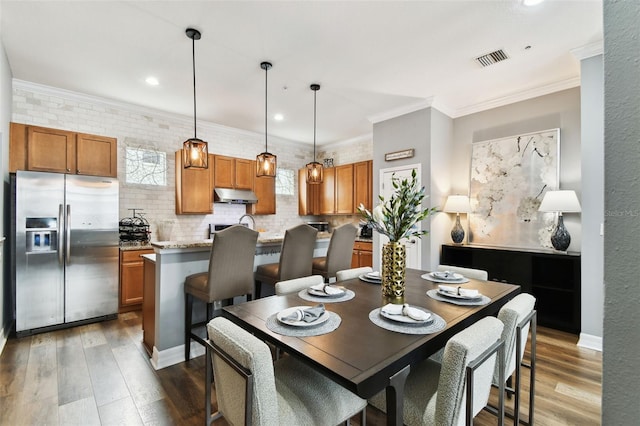 dining room featuring a wealth of natural light, crown molding, and dark hardwood / wood-style floors