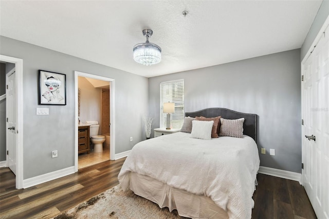 bedroom with dark hardwood / wood-style flooring and ensuite bath