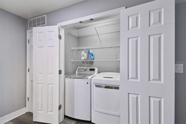 washroom featuring dark hardwood / wood-style flooring and washer and clothes dryer