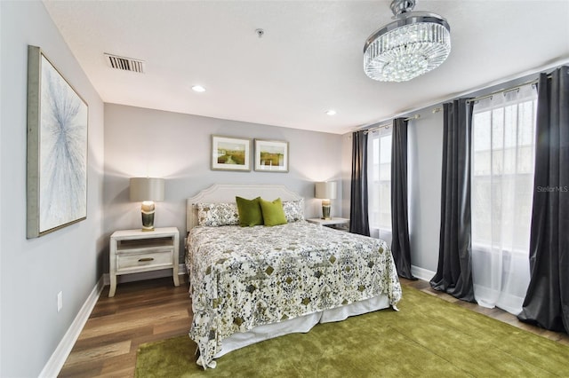 bedroom with hardwood / wood-style floors and a chandelier