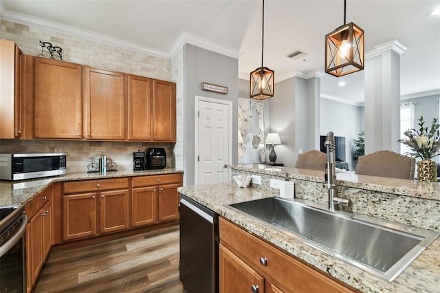 kitchen with decorative light fixtures, crown molding, sink, and appliances with stainless steel finishes