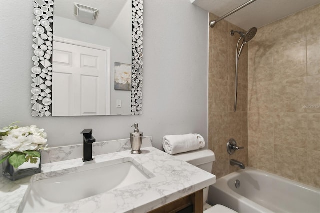 full bathroom with vanity, toilet, and tiled shower / bath