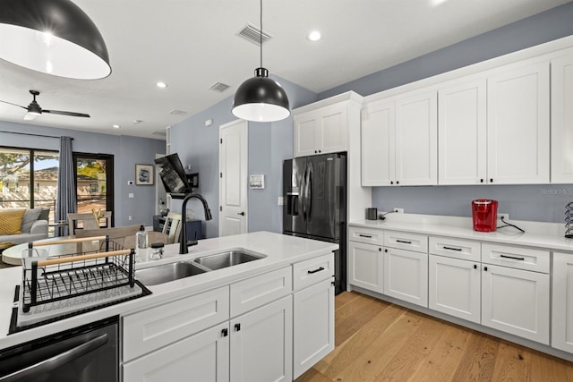 kitchen featuring white cabinetry, sink, light hardwood / wood-style flooring, refrigerator with ice dispenser, and pendant lighting