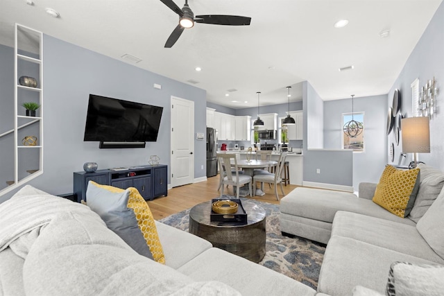 living room featuring light hardwood / wood-style flooring and ceiling fan