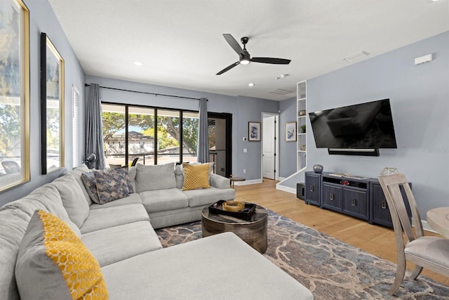 living room with light hardwood / wood-style flooring and ceiling fan