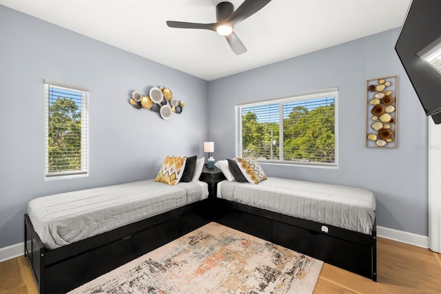 bedroom with light hardwood / wood-style floors, multiple windows, and ceiling fan