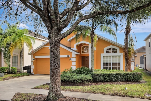 view of front of home with a garage, concrete driveway, and stucco siding