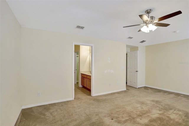 carpeted spare room featuring ceiling fan