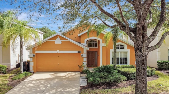 view of front of property with driveway, an attached garage, and stucco siding