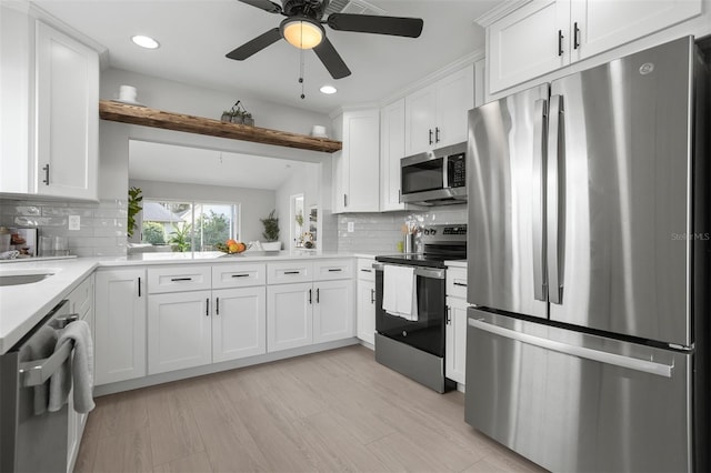 kitchen with stainless steel appliances, light hardwood / wood-style floors, white cabinets, and backsplash