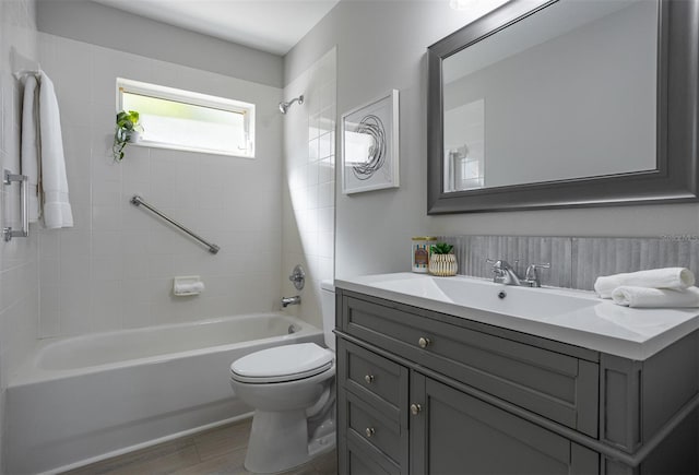 full bathroom with vanity, wood-type flooring, tiled shower / bath, and toilet