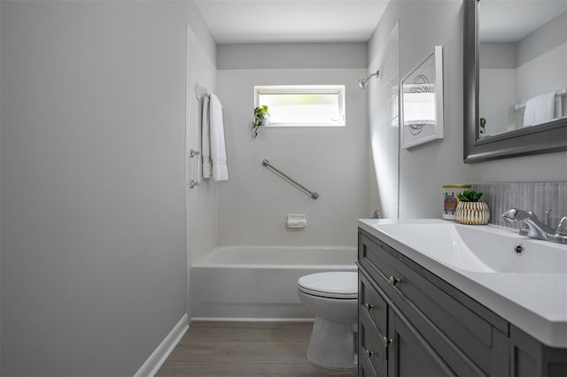 full bathroom featuring hardwood / wood-style flooring, vanity, toilet, and tiled shower / bath