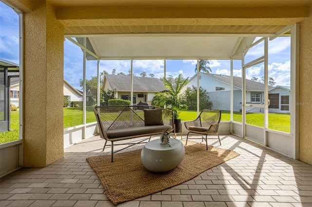 sunroom featuring beamed ceiling and plenty of natural light