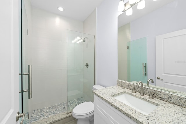 bathroom featuring vanity, an enclosed shower, and toilet