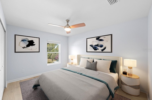 bedroom featuring ceiling fan, a closet, and light wood-type flooring