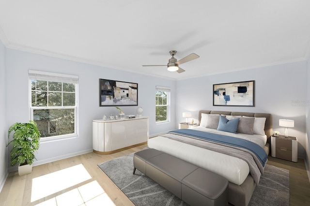 bedroom featuring light hardwood / wood-style flooring, ceiling fan, and ornamental molding