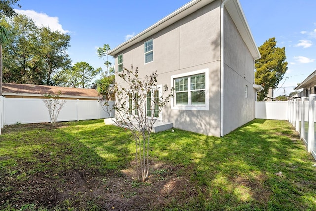 rear view of property featuring a yard