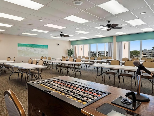 dining area featuring carpet floors, a paneled ceiling, and ceiling fan