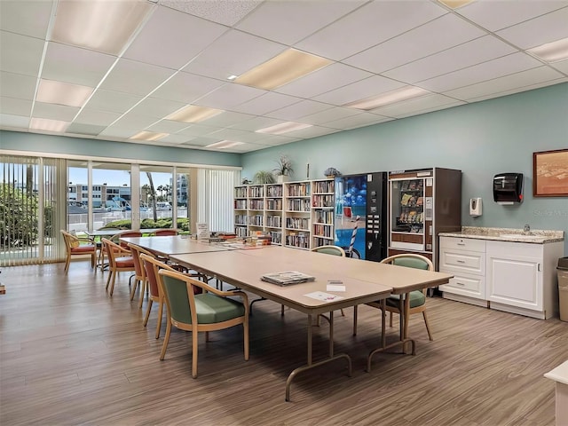 dining area featuring light hardwood / wood-style floors and a paneled ceiling