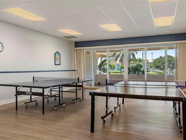 recreation room featuring hardwood / wood-style flooring and a paneled ceiling