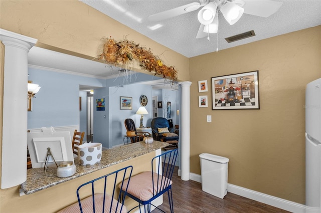 kitchen featuring decorative columns, a textured ceiling, ceiling fan, and dark hardwood / wood-style floors