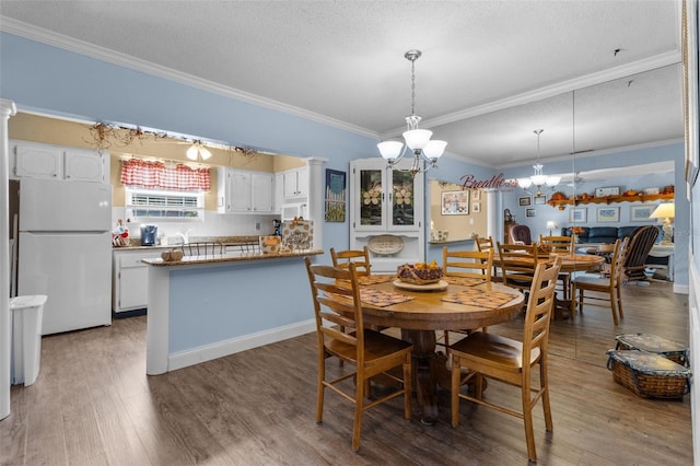 dining space featuring a textured ceiling, hardwood / wood-style flooring, and crown molding