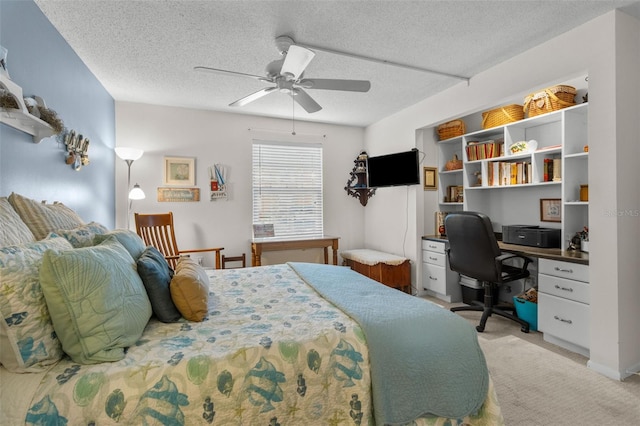 bedroom with a textured ceiling, light colored carpet, and ceiling fan