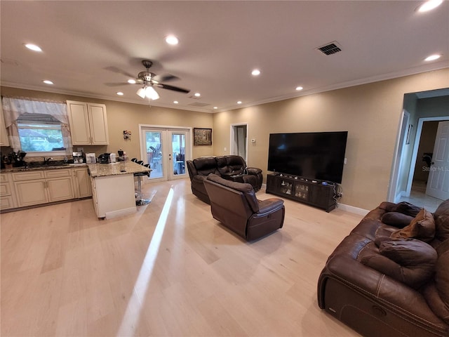 living room with ceiling fan, a healthy amount of sunlight, light wood-type flooring, and french doors