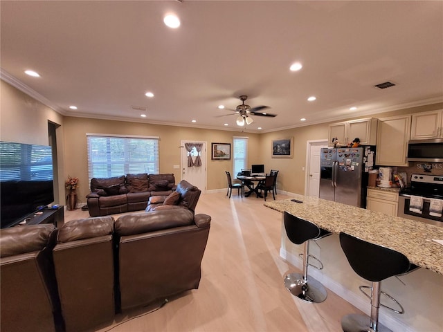 living room with ceiling fan and ornamental molding