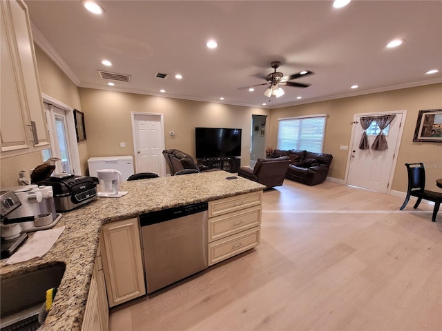 kitchen with dishwasher, cream cabinetry, and light stone countertops