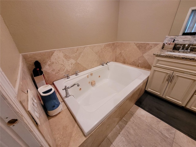 bathroom featuring a washtub, vanity, tile patterned floors, and tile walls