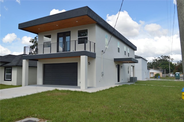 view of home's exterior featuring a balcony, a garage, central AC, a yard, and stucco siding