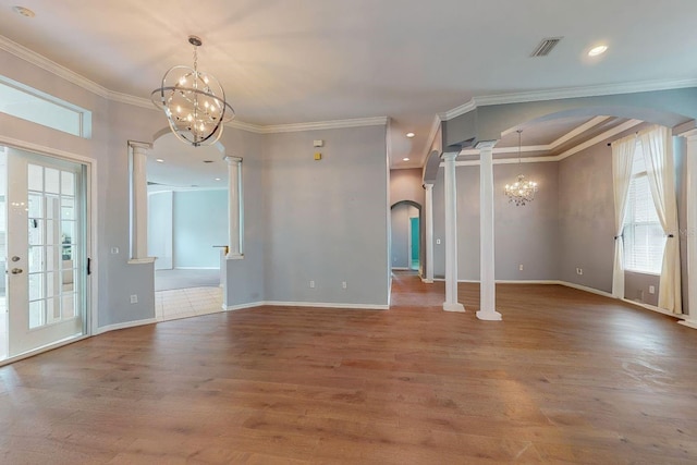 interior space featuring ornamental molding, an inviting chandelier, hardwood / wood-style floors, and ornate columns