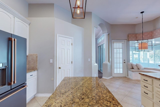 kitchen featuring decorative light fixtures, light stone counters, white cabinetry, and high end fridge