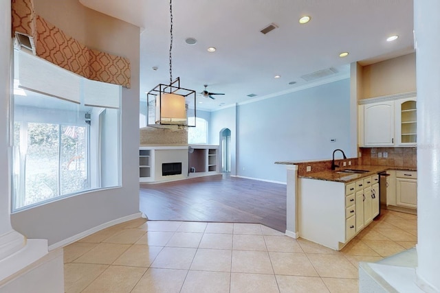 kitchen with decorative light fixtures, white cabinetry, tasteful backsplash, sink, and light tile patterned floors