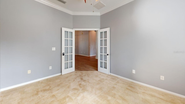 spare room featuring light carpet, ornamental molding, and french doors