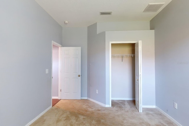 unfurnished bedroom featuring a closet and light carpet