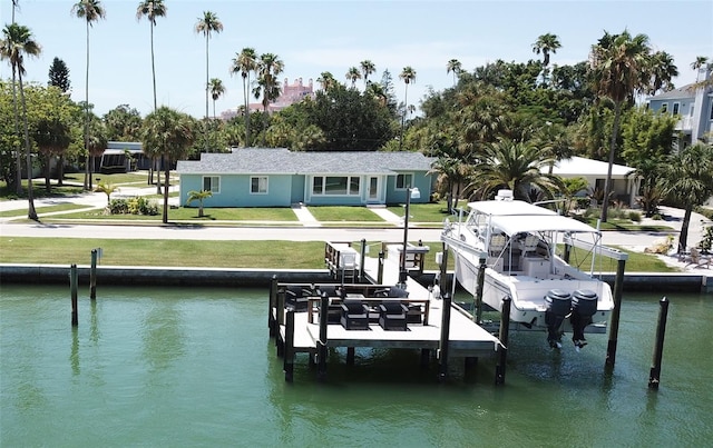 view of dock with a water view and a yard