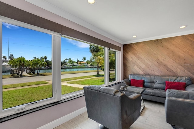 living room with light hardwood / wood-style flooring, a water view, and ornamental molding