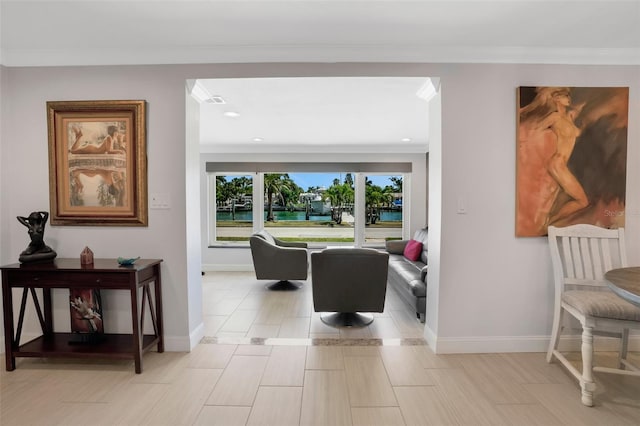 living room with a water view and crown molding