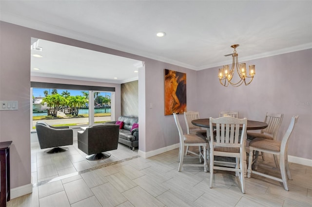 dining space featuring crown molding, a water view, and a notable chandelier