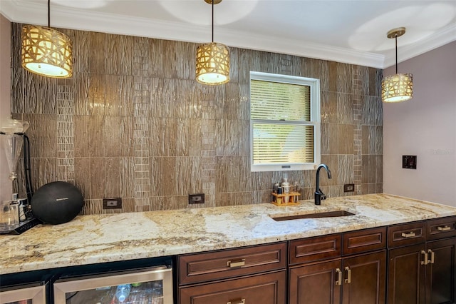 bar with wine cooler, hanging light fixtures, ornamental molding, and sink